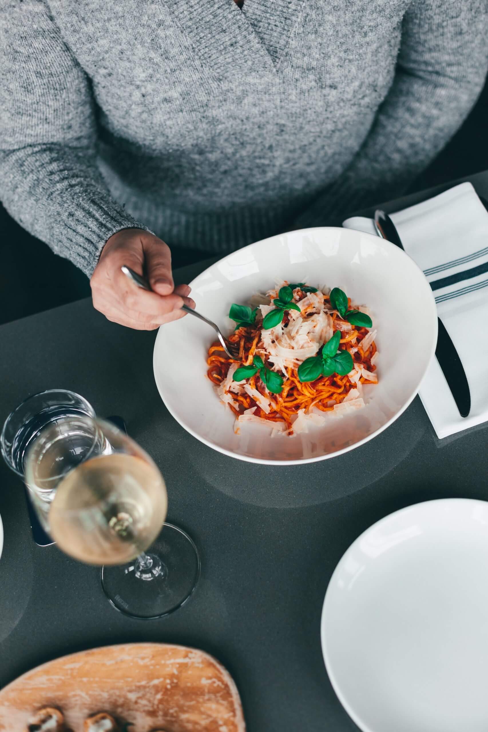 A person eating a plate of Pasta. Make a reservation!