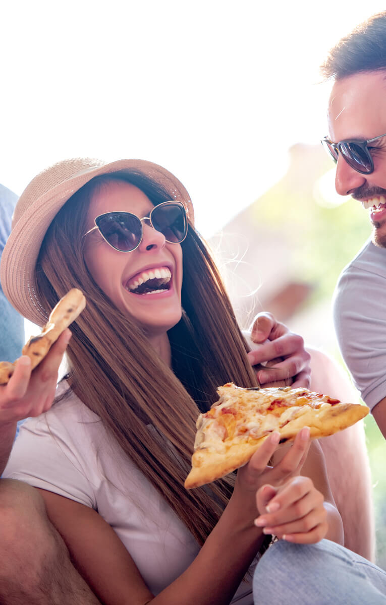 Laughing Girl eating Pizza and earning Rewards with Rosti Rewards