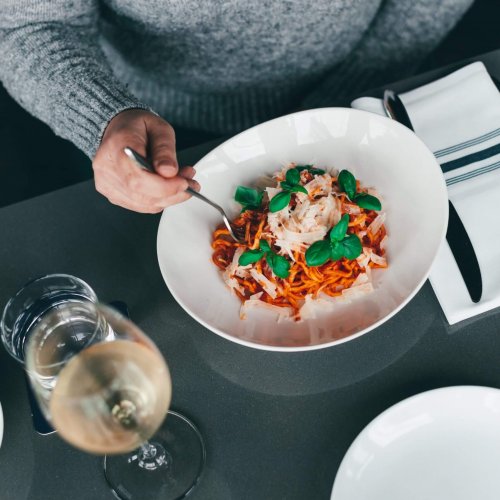 A person eating a plate of Pasta. Make a reservation!